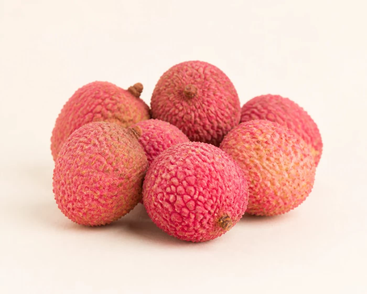 Fresh Rose Scented Litchi arranged on a warm off-white surface.