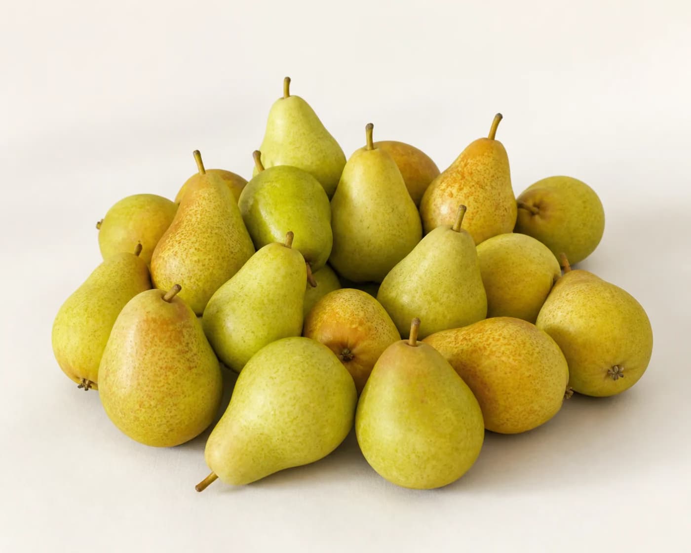 Fresh Babbugosha Pear arranged on a warm off-white surface.